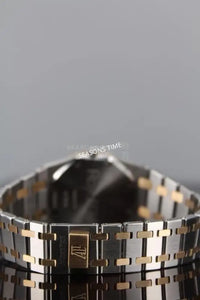 A two-tone metal watch bracelet with a gold clasp